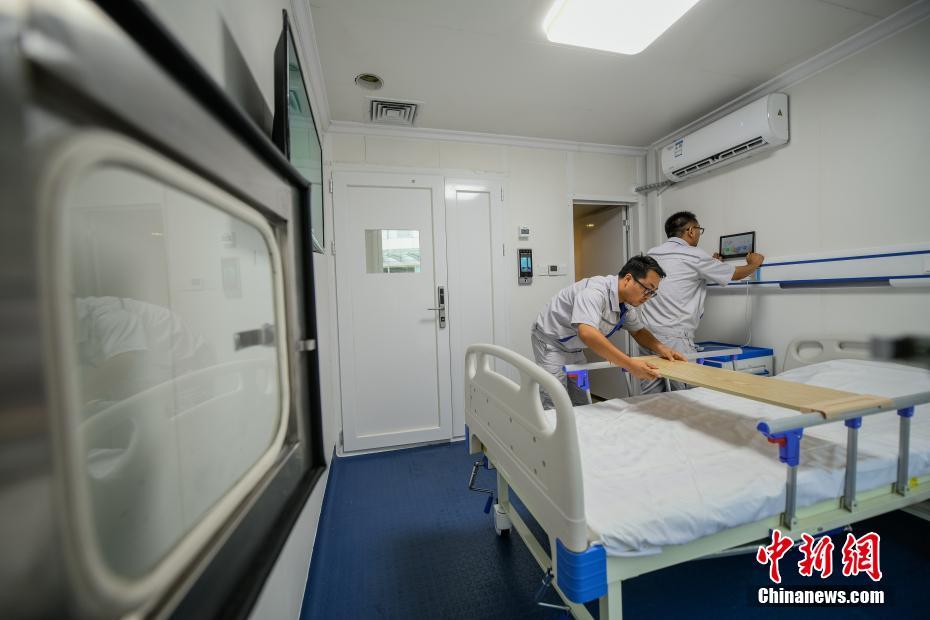 8月12日，工作人员在隔离单元内调试设备。近日，中国首个按照新颁布国家标准制造的应急医用隔离单元产品样箱试制工作在天津中冶天工集团完成，该单元主体采用钢结构密闭集装箱模块设计，水电接口全部采用模块化快速插接模式，内置病床、空调、闭路电视、无线网、紧急广播、独立卫浴、紫外线灭菌传递窗等设施，满足各种工况条件下独立及组合使用。中新社记者 佟郁 摄