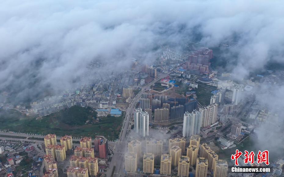 近日，贵州省黔西南布依族苗族自治州安龙县城乡上空云雾缭绕，高空俯瞰楼房与远山在雾中若隐若现，宛若仙境。 刘朝富 摄