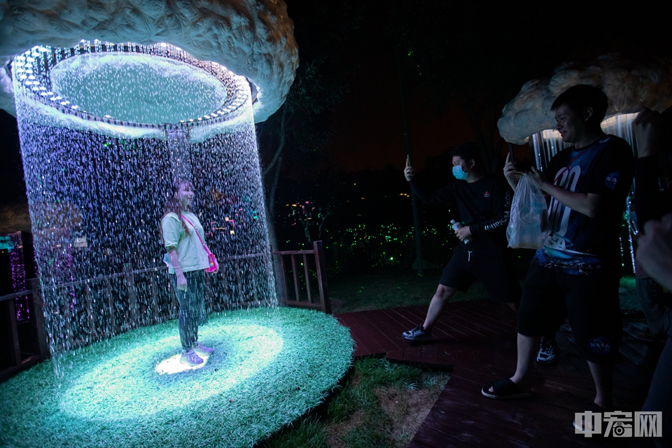 8月21日，北京玉渊潭公园，一名游客在户外光影艺术沉浸式体验展上体验光影作品。中宏网记者 康书源 摄