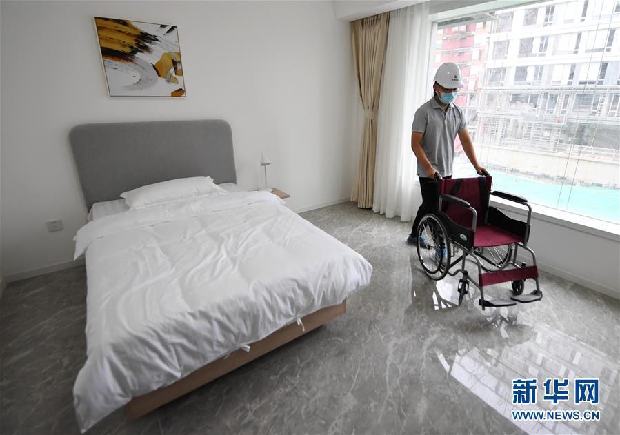 9月12日，工作人员展示北京冬奥村样板间内无障碍通行。 当日，北京冬奥村样板间对外亮相，此次亮相的是220平米的户型，每套提供三间单人间和一个双人间，所有房间均设立了完备的无障碍设施，满足残疾人运动员的居住需要。 承载着“健康建筑”理念的北京冬奥村计划于今年年底实现完工，将在2022北京冬奥会期间作为运动员及随行官员居住生活的地方。 新华社记者 张晨霖 摄