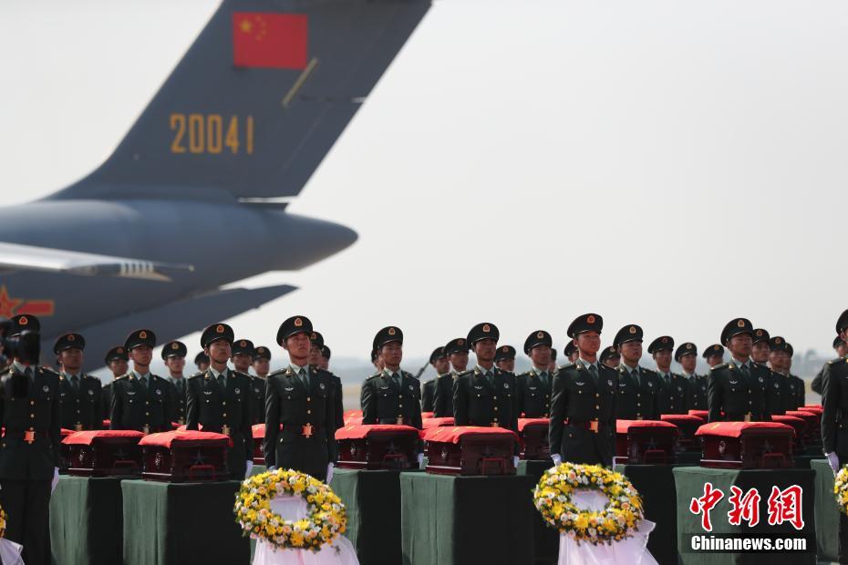 9月27日，沈阳桃仙国际机场，第七批在韩中国人民志愿军烈士遗骸由中国空军专机护送从韩国接回辽宁沈阳。机上共载有117位志愿军烈士的遗骸及相关遗物。图为礼兵将殓放志愿军烈士遗骸的棺椁从专机上护送至棺椁摆放区。中新社记者 于海洋 摄