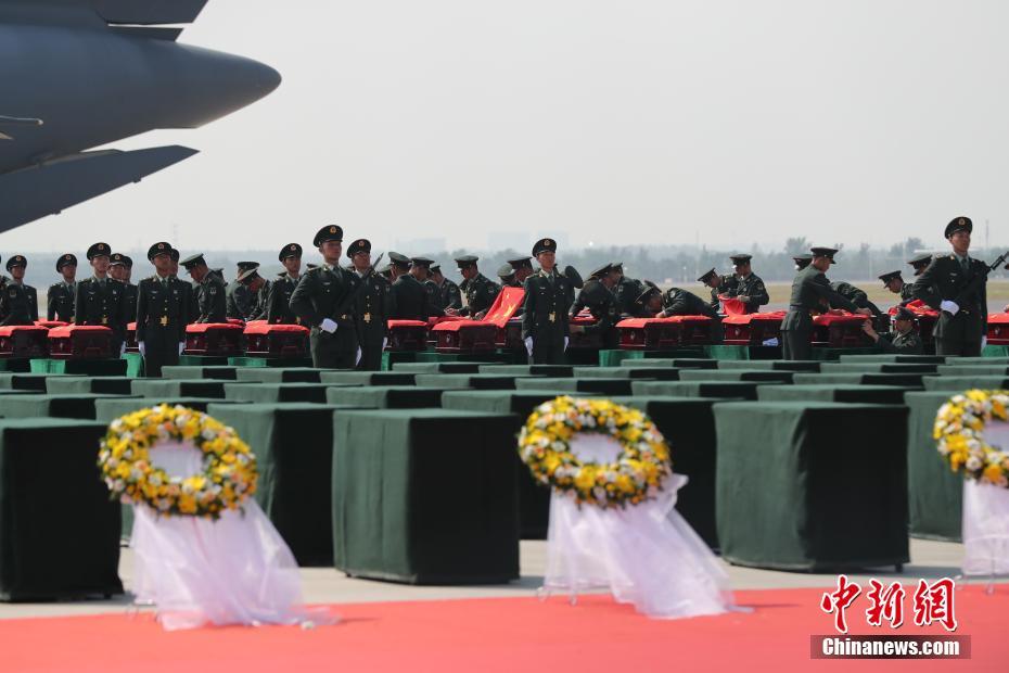 图为礼兵在殓放志愿军烈士遗骸的棺椁上盖上国旗。中新社记者 于海洋 摄