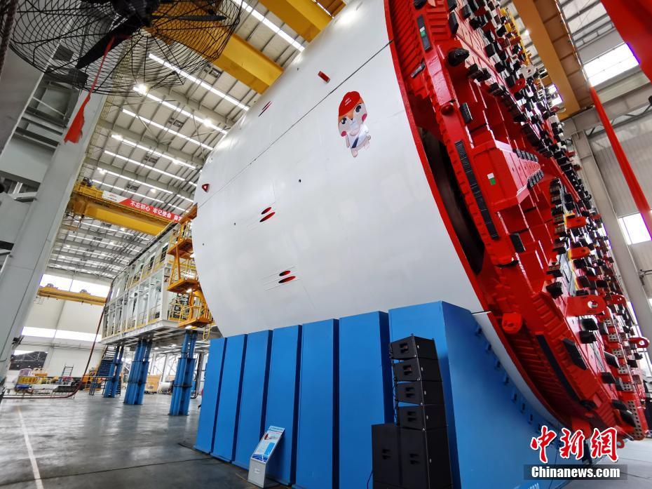 9月27日，一台最大开挖直径达16.07米的超大直径盾构机在湖南长沙下线，这是中国迄今研制的最大直径盾构机。该盾构机由中国铁建重工集团股份有限公司、中铁十四局集团有限公司联合研制，是中国企业首次成功实现16米级超大直径盾构机的工业制造。这台“巨无霸”设备整机长150米，总重量4300吨，犹如一条钢铁巨龙横卧车间，刀盘涂装以京剧中的红色脸谱为设计原型。设备取名“京华号”，出厂后将参与北京东六环改造工程建设。 中新社记者 向一鹏 摄