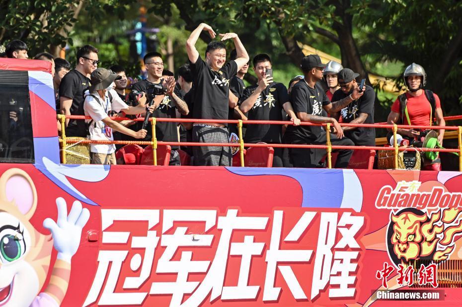 10月11日，广东宏远队在广州市的长隆旅游度假区举行2019-2020赛季CBA总冠军巡游活动。图为广东宏远队主教练杜锋（中）在巡游大巴车上向球迷示意。中新社记者 陈骥旻 摄