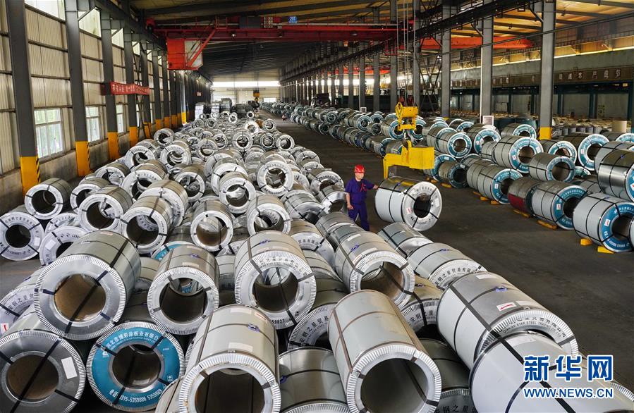 河北省迁安市一家钢铁外贸企业的工人在生产车间内吊装彩涂板（7月13日摄）。新华社记者 牟宇 摄