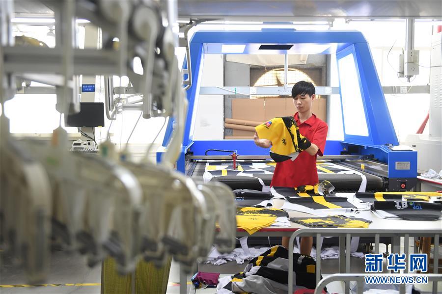 福建省石狮市一家服饰有限公司工人在激光切片机前操作（8月25日摄）。新华社记者 宋为伟 摄