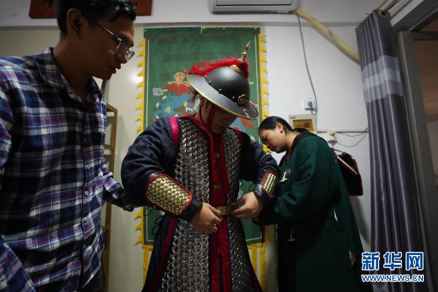 “虔州武备司”成员曾繁强（左）、邱梓崇（右）帮黄正源穿上明代铠甲。新华社记者 周密 摄