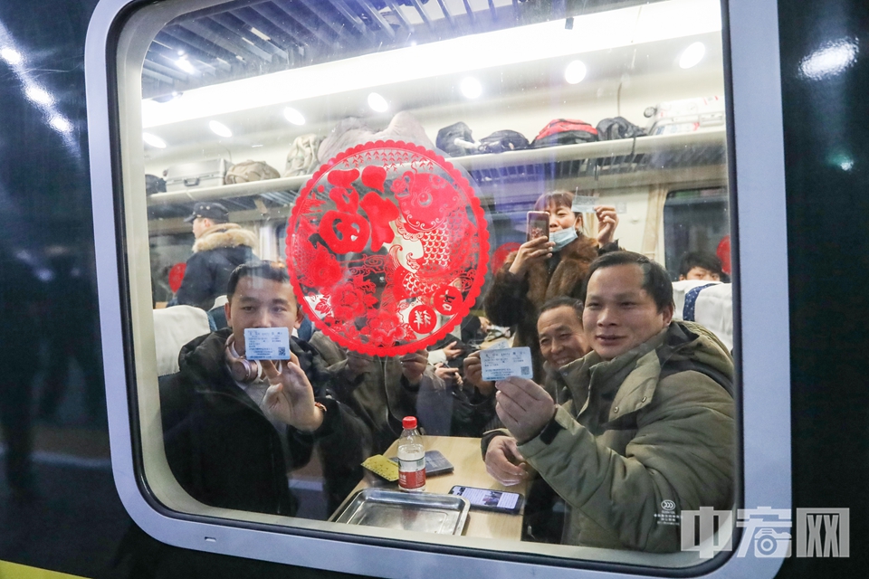 2020年1月10日0点29分，由北京开往江苏省南通市的K4051次列车从北京站准时发车，2020年春运由此拉开帷幕。图为踏上春运首班列车的乘客在窗前展示车票。  中宏网记者 康书源 摄