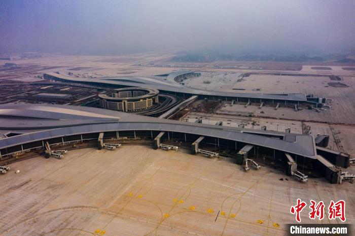 目前成都天府国际机场已建成T1、T2两座航站楼，每个航站楼均由A、B、C三个指廊组成。T1航站楼A指廊12个登机口中，有4个超大登机桥，这是国内目前拥有超大登机桥最多的航站楼，可同时容纳多个大型飞机停靠。图为鸟瞰成都天府国际机场T1航站楼A指廊一侧。　张鼎 摄