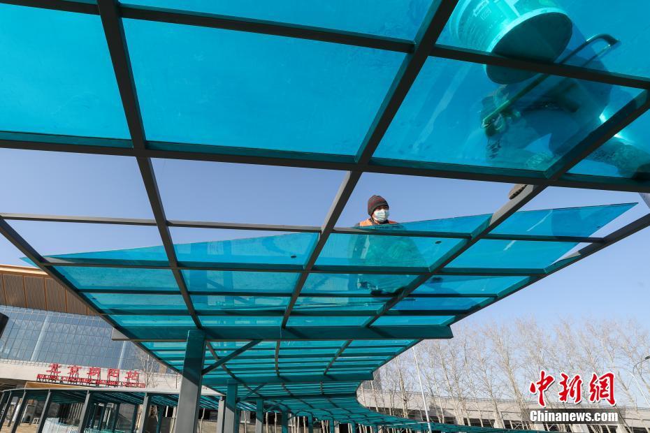 1月17日，北京朝阳站东侧进站口，工人正在安装走廊雨棚最后一块盖板。北京朝阳站是京哈高铁始发站，整体施工已经进入最后的收尾阶段，开通在即。 中新社记者 贾天勇 摄