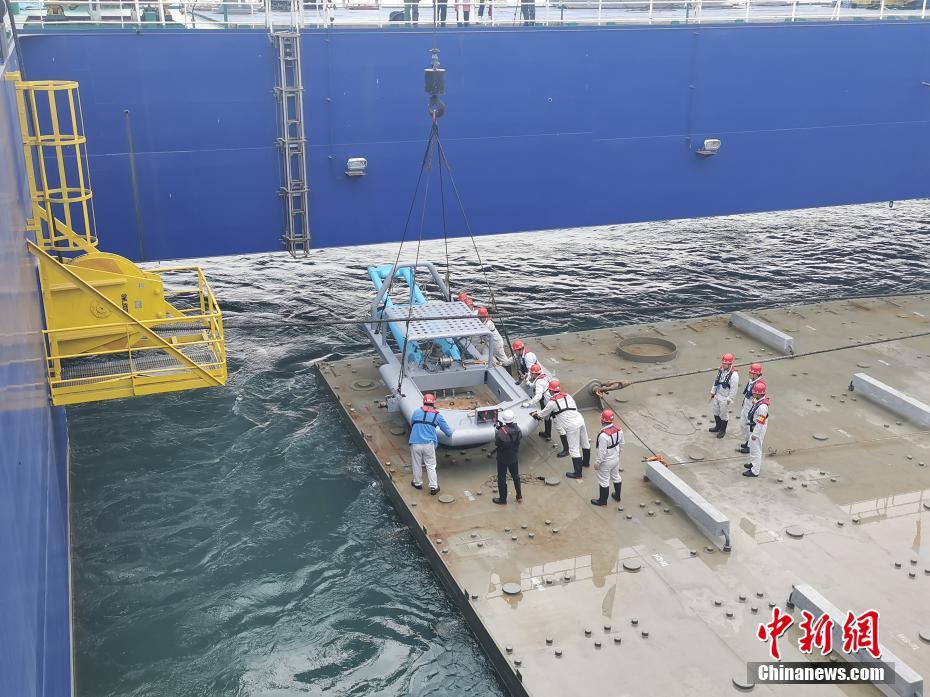 1月22日，位于广东省的深中通道E7管节完成沉放对接，项目沉管隧道安装突破千米大关，同时，深中通道伶仃洋大桥西锚碇底板施工全部完成。图为1月21日，作业人员正在进行沉管管顶施工。 中新社发 张子正 摄