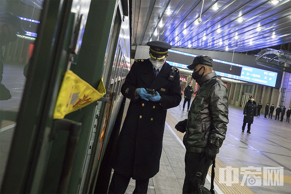 1月28日，北京站，列车员为乘客检票。