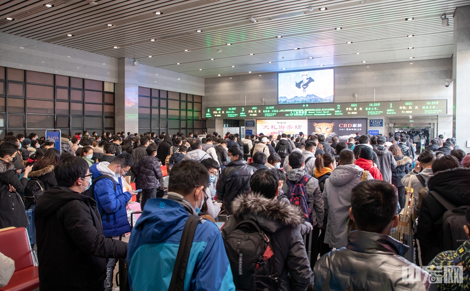 大批旅客在候车室内等待检票上车，由于春节假期的临近，春运的客流明显增长。