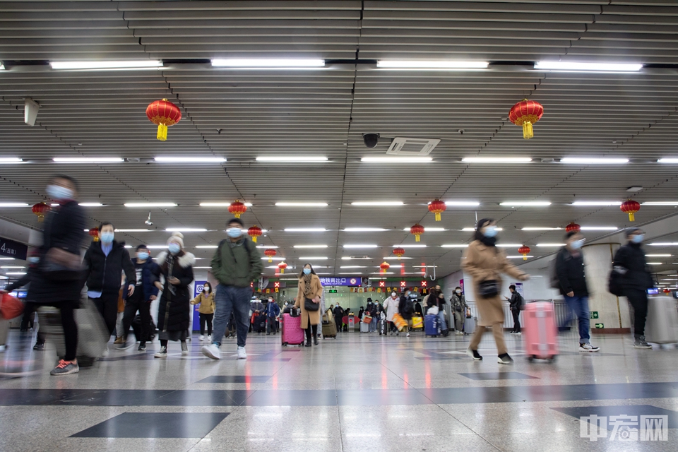 2月8日，旅客拎着“大包小包”从北京西站地铁站前往火车站。