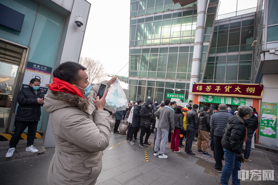 2月26日早上，购得元宵的市民在锦芳小吃磁器口店前拍照。