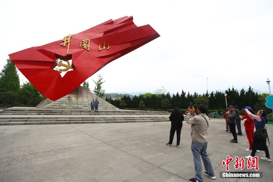 4月11日，游客在江西井冈山的标志性雕塑前参观留影。近日，“中国革命的摇篮”井冈山的红色旅游日渐升温，各地游客前往井冈山革命博物馆、井冈山革命烈士陵园、黄洋界等地参观游览。 中新社记者 刘占昆 摄