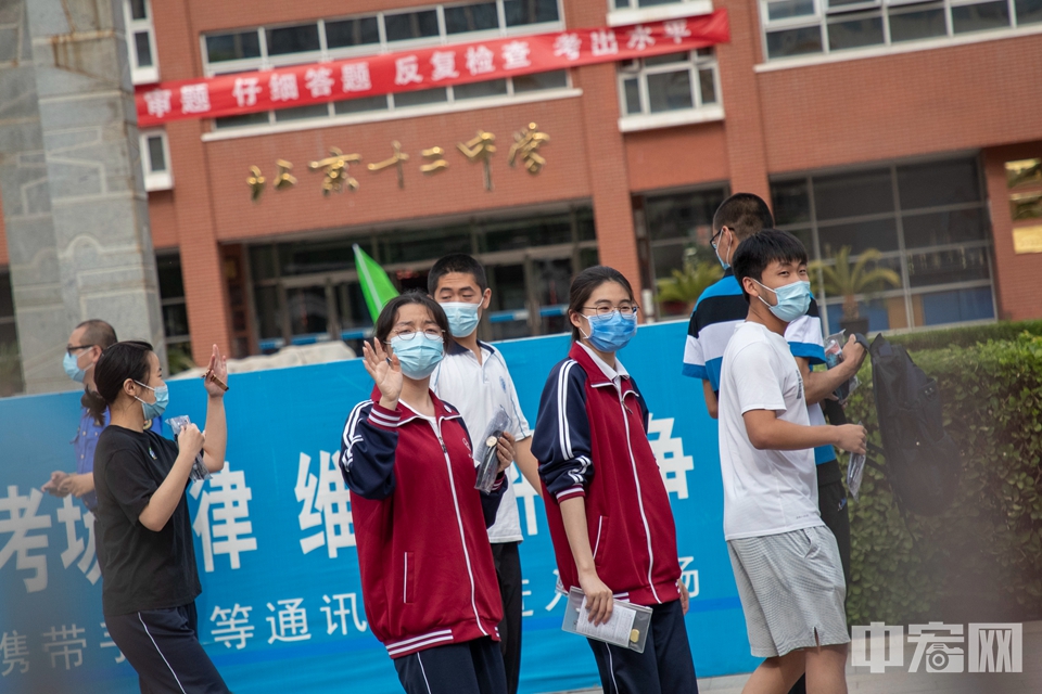 6月7日，北京市第十二中学考点，一名考生在走进考场后与家长挥手。