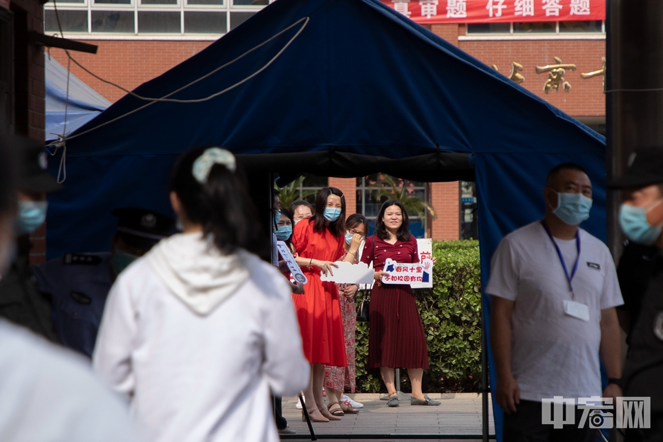 6月7日，北京市第十二中学考点，送考老师手持“春风十里不如校园有你”的牌子等待考生进场。