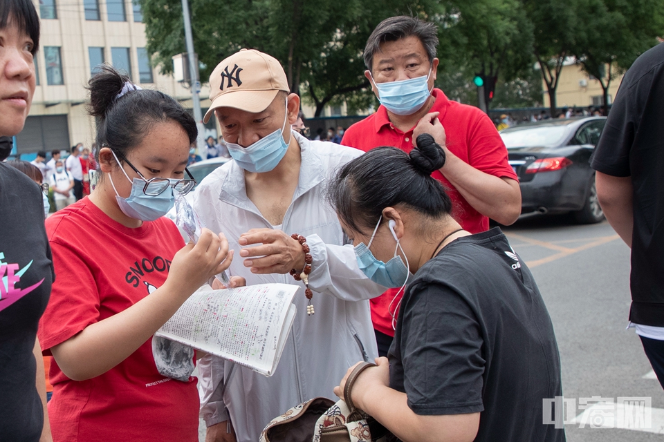 6月7日，北京市第十二中学考点，考生在入场前复习知识点并检查考试用品。