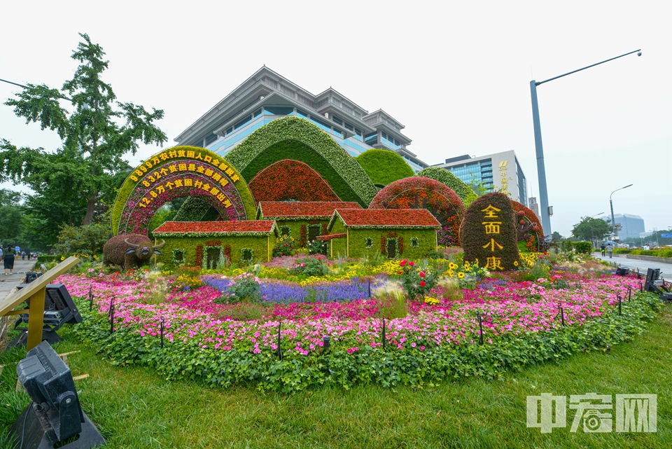 西单“全面小康”主题花坛，以十八洞村旧貌换新颜的幸福生活为场景，体现“全面建成小康社会取得伟大历史性成就，决战脱贫攻坚取得决定性胜利”重要时刻。 中宏网记者 富宇 摄
