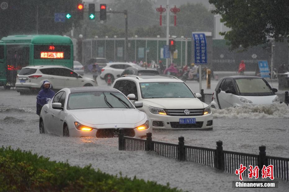 7月20日，河南郑州，车辆经过积水路段。近日，郑州连遭暴雨袭击，持续强降雨导致部分街道积水严重。 中新社记者 李超庆 摄