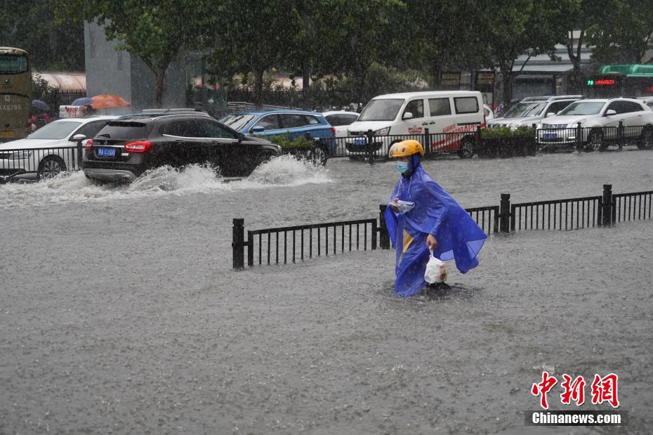 7月20日，河南郑州，一名外卖员在暴雨中送餐。近日，郑州连遭暴雨袭击，持续强降雨导致部分街道积水严重。 中新社记者 李超庆 摄