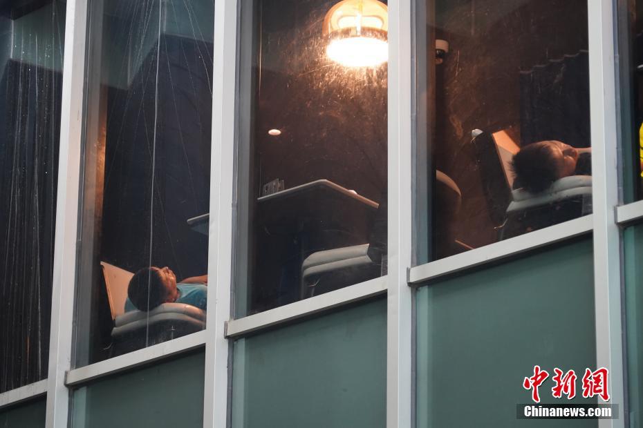 图为郑州市区一商场快餐店接纳的市民已经入睡。中新社记者 阚力 摄<br/>
（中宏网综合整理）