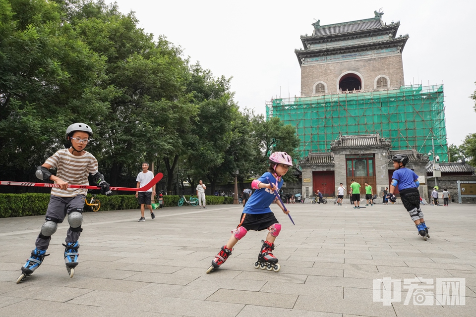 随着2022北京冬奥会的不断临近，北京民众对冬季运动项目的热情不断升高。在北京钟鼓楼广场，几名小朋友练习旱地冰球。 中宏网记者 富宇 摄