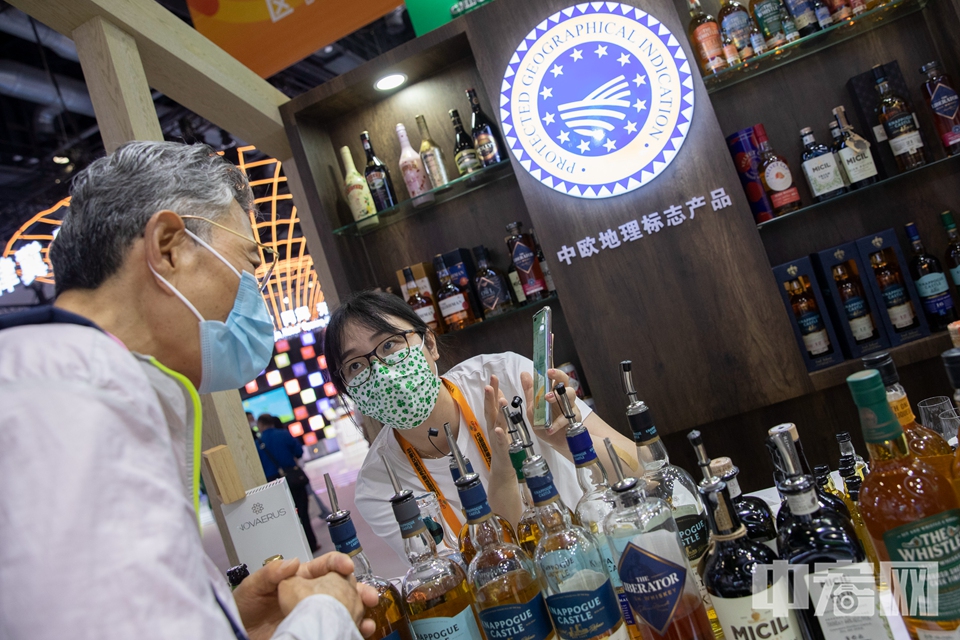 参展商向观众介绍爱尔兰展区的酒类产品。