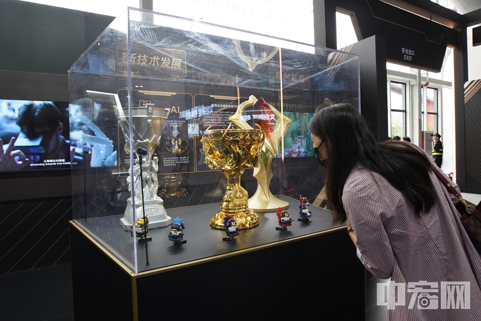 观众被腾讯展出的“和平精英”电竞奖杯吸引。