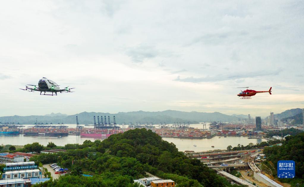9月14日，在深圳市盐田区的东部通航运行基地，一架贝尔206直升机（右）与一台亿航载人级自动驾驶飞行器在同一空域中进行试飞（无人机照片）。新华社发