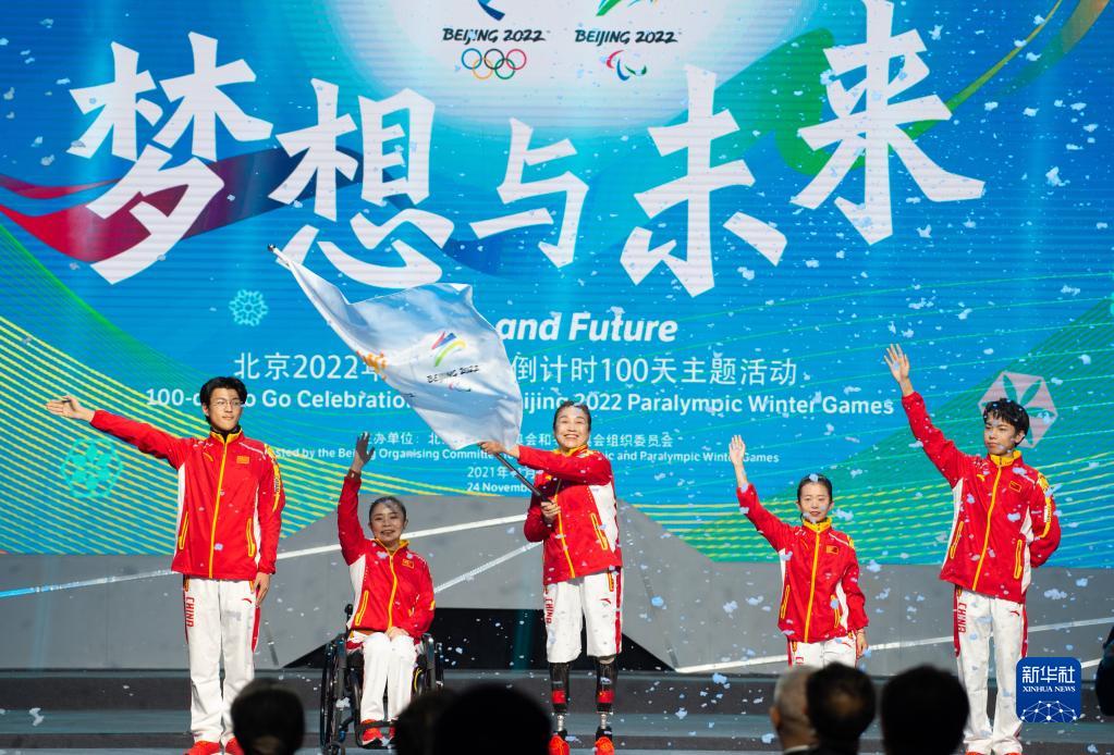 11月24日，冬奥会和冬残奥会赛会志愿者中的残疾人代表挥舞旗帜。当日，北京2022年冬残奥会倒计时100天主题活动在北京举行。新华社记者 陈钟昊 摄