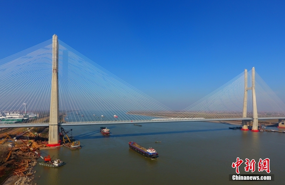 12月1日，江西九江，一列动车组行驶在中国首座交叉索斜拉桥、安九高铁过江通道——鳊鱼洲长江大桥上。当天，安庆至九江高铁进入全线运行试验阶段，标志着这条铁路距离正式通车运营又近一步。（无人机照片）　中新社发 胡国林 摄
