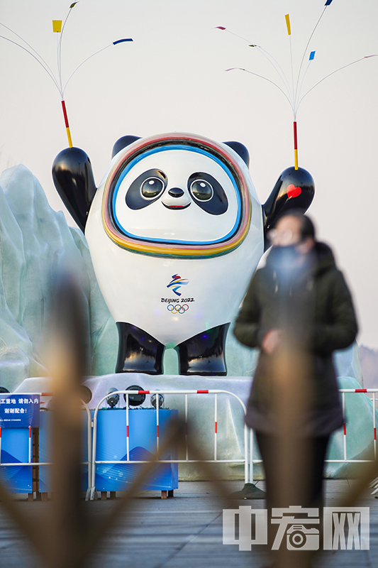 1月18日，市民从北京大屯路的2022年冬奥会吉祥物“冰墩墩”雕塑前经过。 中宏网记者 富宇 摄