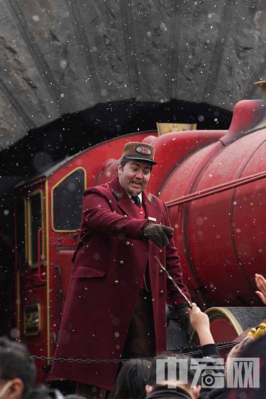 扮演霍格沃茨特快专列列车长的演员在雪中与游客互动。 中宏网记者 富宇 摄