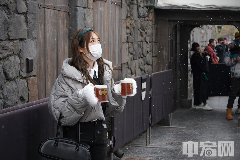 一位游客被空中的雪花吸引。 中宏网记者 富宇 摄