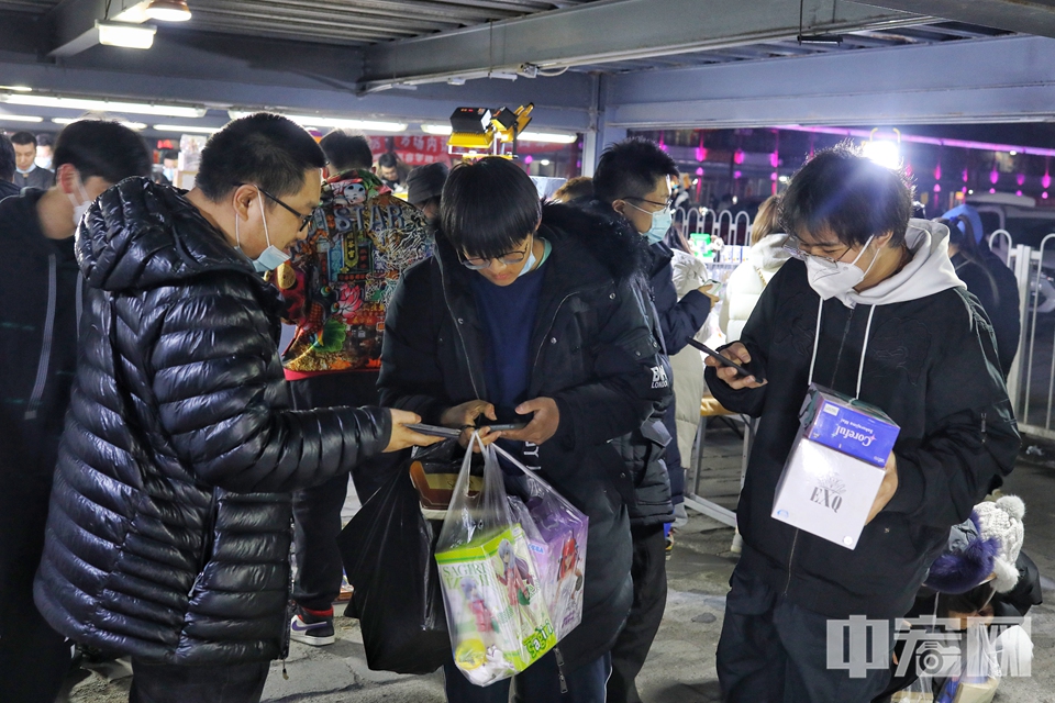 “圣斗士、火影忍者、海贼王看一看都不贵哈。”80后摊主张玉明（前排左一）卖力地吆喝着。“这个是限量版的太空堡垒，看看盒儿都没开过封。”张玉明说，摊位上的商品一部分是自己的收藏，大部分都是淘来的。他说：“在夜市卖东西的过程中能遇到志同道合的摊主，大家就互相交换。聊聊天，交朋友，也是夜市的魅力所在。” 陈硕 摄