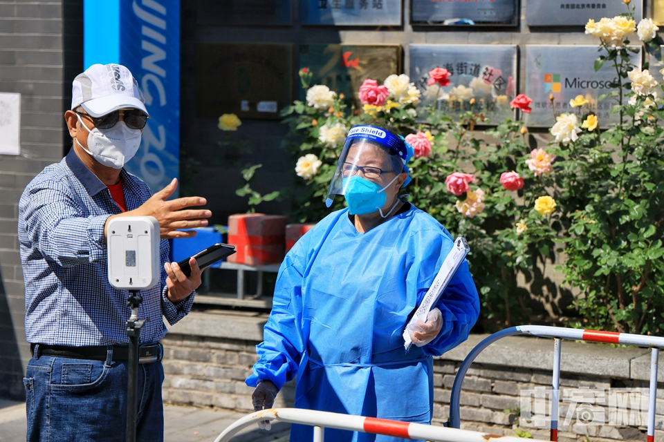 5月16日、17日、18日，北京市东城区、西城区、朝阳区、海淀区、丰台区、石景山区、房山区、通州区、顺义区、昌平区、大兴区、经开区12区继续进行三轮区域核酸筛查。图为北京西城区什刹海街道松树街社区、西海社区检测点，居民进行核酸采样。陈硕 摄