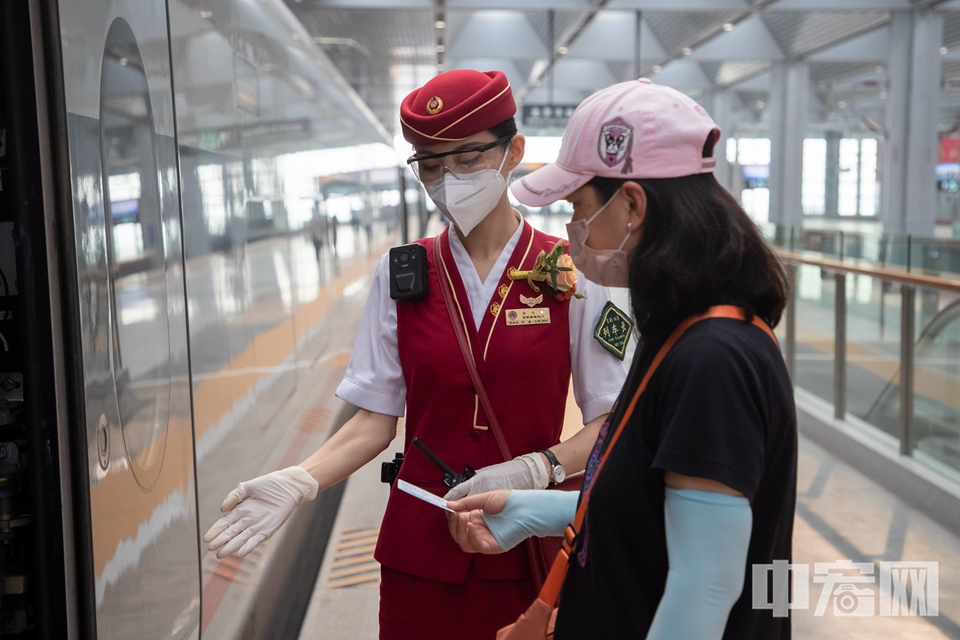 6月20日，北京丰台站，列车长引导旅客上车。中宏网记者 康书源 摄
