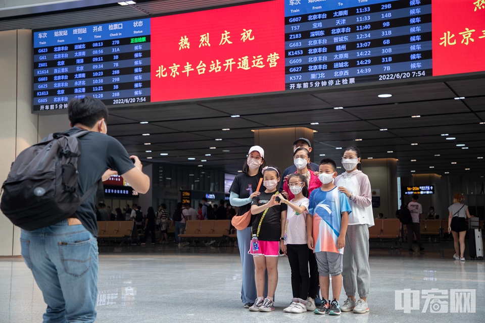 图为2022年6月20日，北京丰台站正式开通运营，乘客在候车大厅拍照留念。