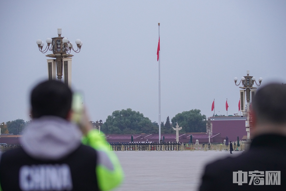 6点38分，天安门广场举行升旗仪式，选手在比赛场地驻足观看。中宏网记者 康书源 摄