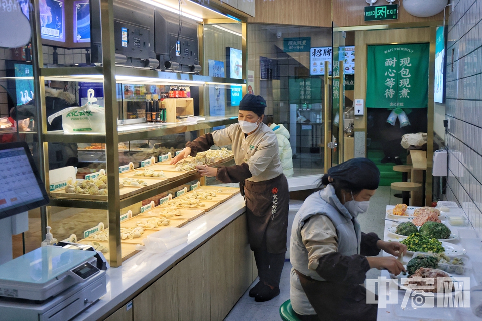 12月7日晚，西城区一家饺子店内，店员正在紧张地包着饺子，寒冷的冬天，一盘热腾腾的饺子就能给人们带来一阵小满足。 陈硕 摄