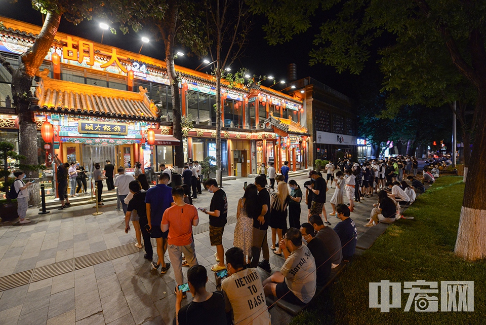 6月6日0时，在北京东城区簋街一家餐厅外，等候就餐的市民排起长队。当日，北京除丰台区全域及昌平区部分区域外，餐饮经营单位开放堂食服务。