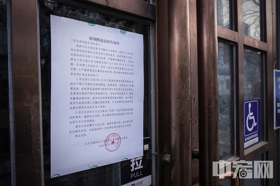 一家大门紧闭的酒吧门上贴着《限期腾退房屋告知书》。 中宏网记者 富宇 摄