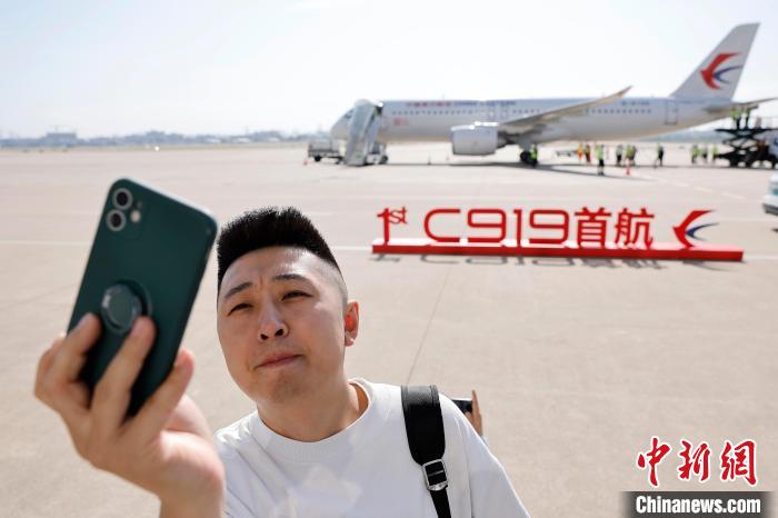 5月28日上午10时32分，中国东方航空使用中国商飞全球首架交付的C919大型客机，执行MU9191航班，从上海虹桥机场飞往北京首都机场，开启这一机型全球首次商业载客飞行。图为首航旅客在飞机边合影。 殷立勤 摄