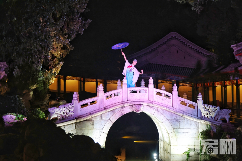 沁泉廊静谧深邃的池水边，伞舞《雨碎江南》梦幻清新，演员持伞在玉带桥上漫舞，灵动的影子映在古建上。 陈硕 摄