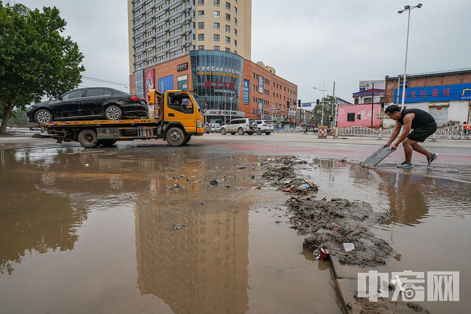 8月7日，记者走进涿州城区，探访灾后现状。图为在甲秀路与华阳路口，一名来自山东的志愿者正在清理积水。 中宏网记者 富宇 摄