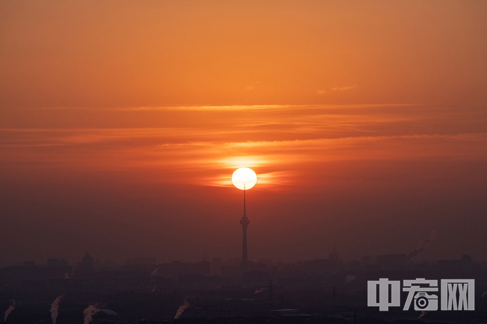 2024年1月1日，新年第一缕阳光洒向大地。图为在北京西山森林公园拍摄的日出与中央电视塔。 中宏网记者 富宇 摄