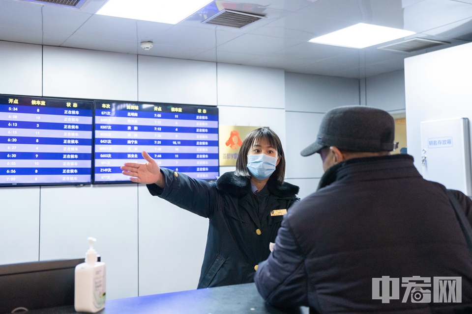 1月26日，北京西站，工作人员引导旅客乘车。