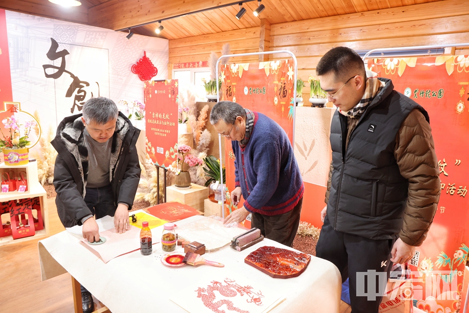 木版年画非遗传承人，带领游客进行龙纹木板拓印活动，游客根据自己的喜好拓印龙年年画、主题红包，近距离体味传统文化的独特魅力。 陈硕 摄